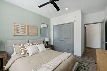 a bedroom with a large bed and a ceiling fan at The Maddox Luxury Apartment Homes, Buckeye, AZ
